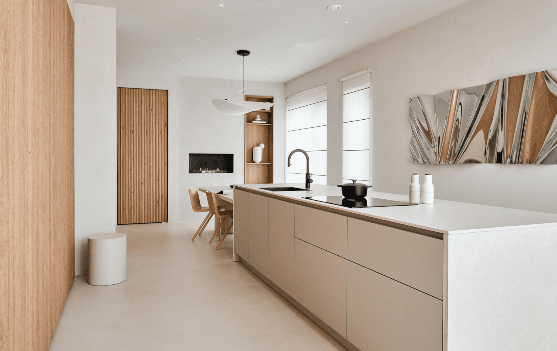 Lichte, minimalistische woonkeuken met kookeiland, houten accenten en designverlichting in Atelier Oost – The Townhouse van bewoner Roos.